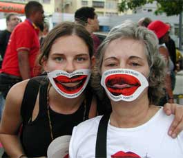Participants at the 2006 World Social Forum in Caracas, Venezuela wear masks that read "Your mouth, fundamental against fundamentalism" both in English and Spanish.